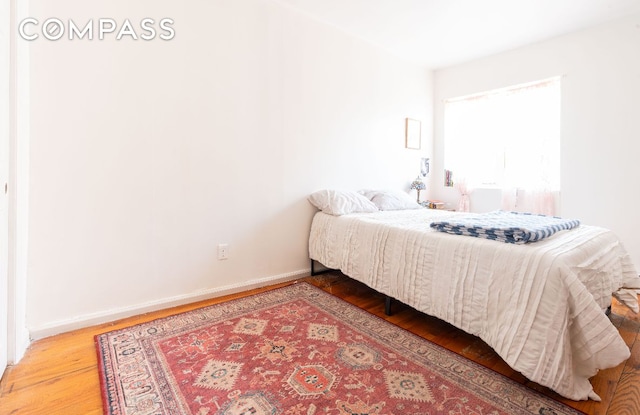 bedroom with baseboards and wood finished floors