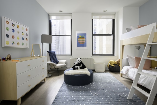 bedroom with multiple windows and wood finished floors