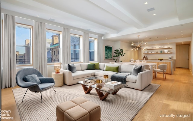 living room with a notable chandelier, beamed ceiling, light wood-type flooring, and recessed lighting