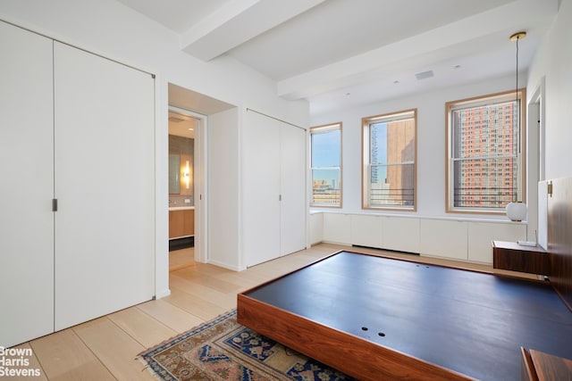 playroom featuring beamed ceiling and light wood-style flooring