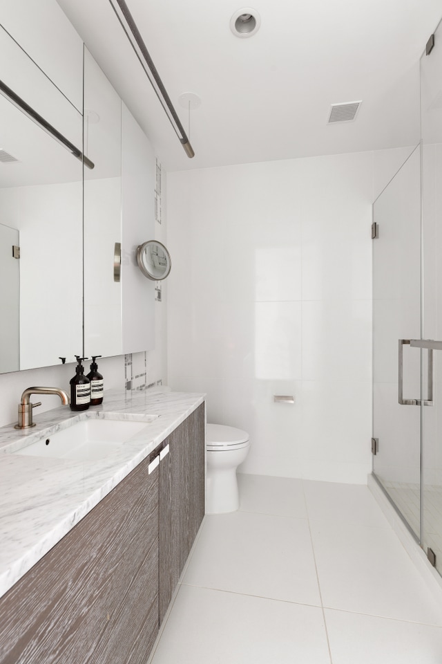 full bathroom featuring tile patterned flooring, visible vents, vanity, toilet, and a stall shower
