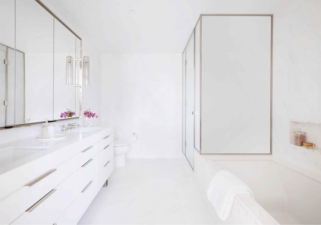 bathroom with toilet, double vanity, a stall shower, and a tub to relax in