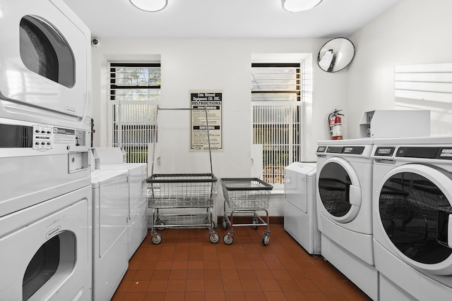 shared laundry area featuring stacked washer and dryer, washing machine and dryer, and dark tile patterned flooring