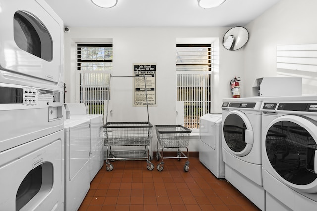 common laundry area with dark tile patterned flooring, stacked washer / dryer, and washing machine and clothes dryer