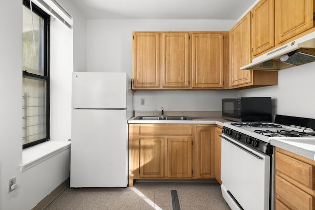 kitchen featuring white appliances, light countertops, a sink, and under cabinet range hood