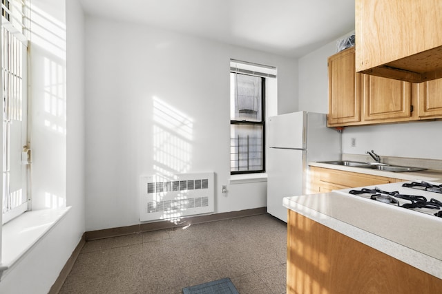 kitchen with light countertops, freestanding refrigerator, and baseboards