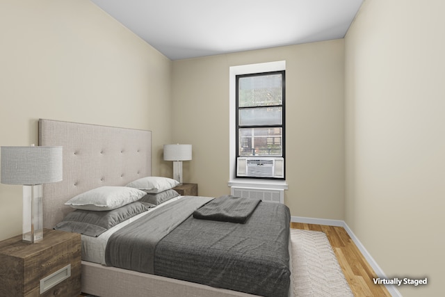bedroom featuring baseboards, wood finished floors, and cooling unit