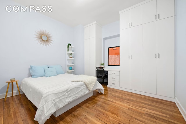 bedroom featuring light wood-style flooring and baseboards