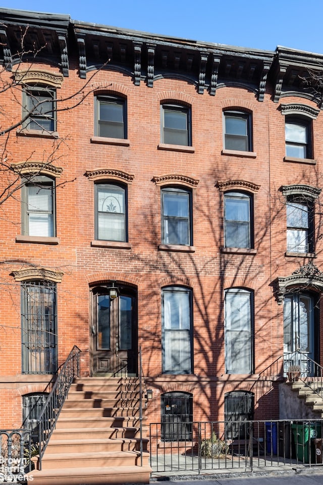 townhome / multi-family property featuring brick siding and fence