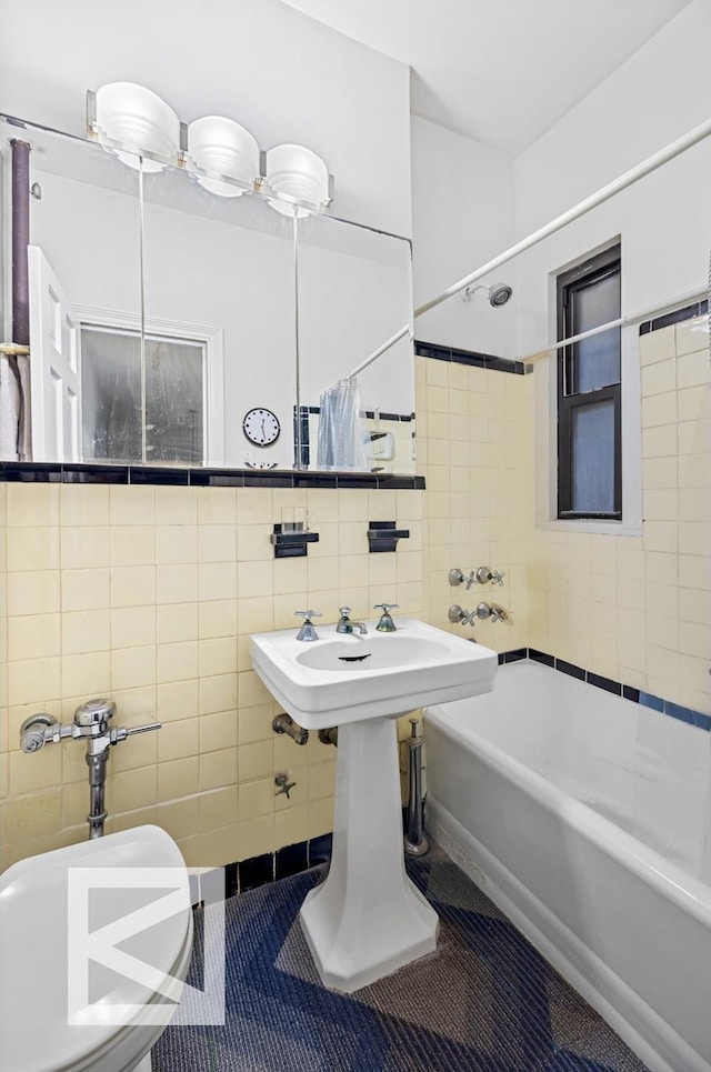full bath with tile patterned flooring, tile walls, toilet, and shower / bath combination