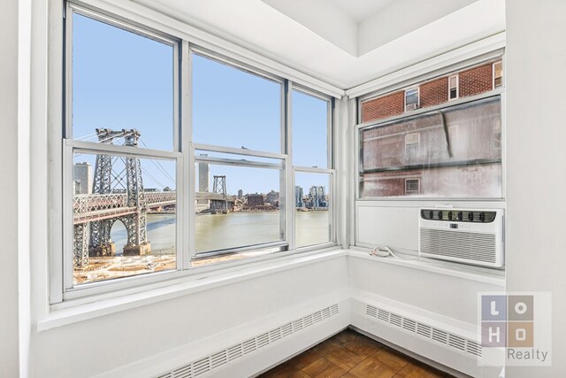 interior space featuring a water view, baseboard heating, and a view of city