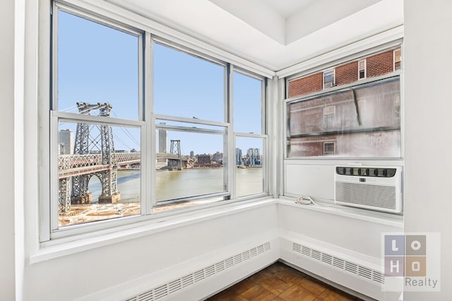 interior space featuring a baseboard heating unit, a view of city, and a water view