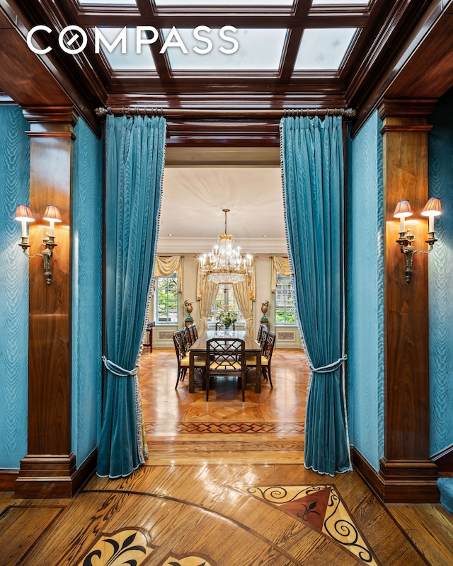 dining space featuring crown molding, a healthy amount of sunlight, coffered ceiling, and a notable chandelier