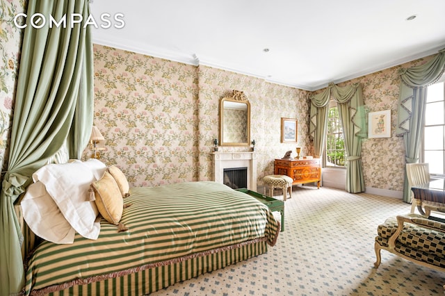 carpeted bedroom featuring baseboards, a fireplace, crown molding, and wallpapered walls