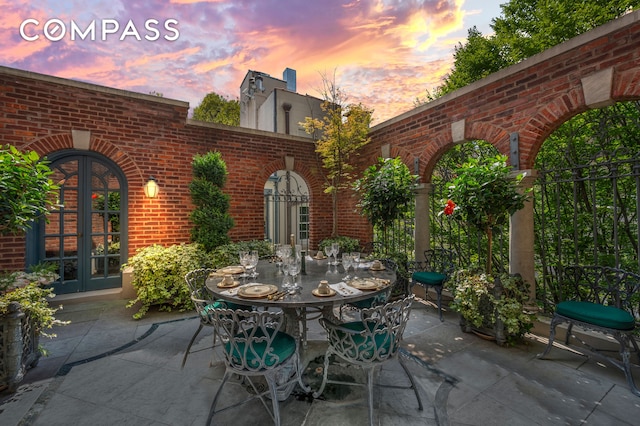 patio terrace at dusk featuring french doors and outdoor dining space