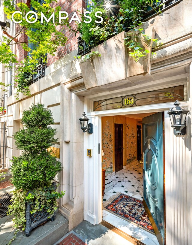 corridor with wallpapered walls, crown molding, and arched walkways