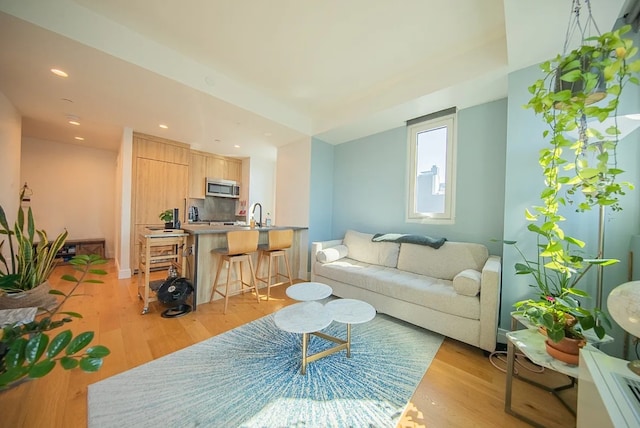 living area featuring light wood finished floors and recessed lighting