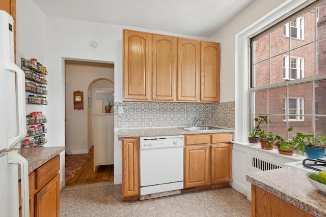 kitchen featuring light countertops, white appliances, granite finish floor, and a sink