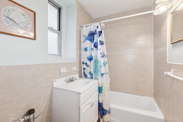 bathroom with shower / bath combo with shower curtain, tile walls, and vanity