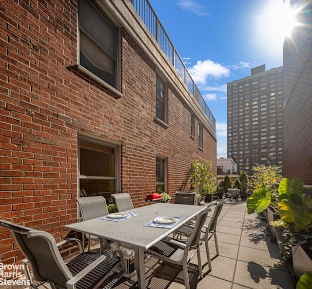 view of patio with outdoor dining area and a city view