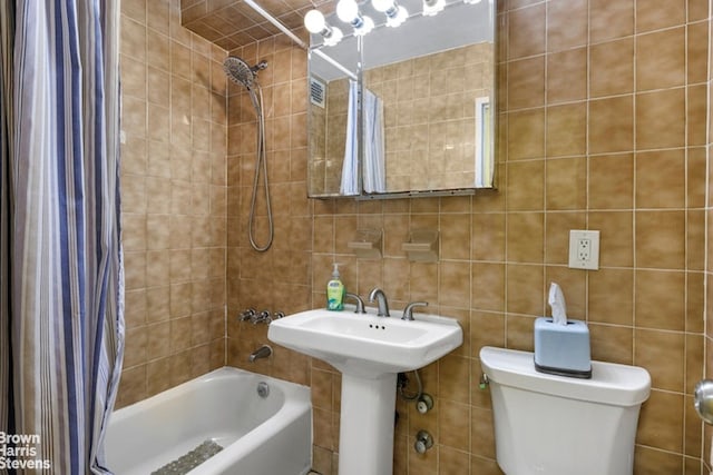 420 E 55th St Unit 11M, New York City, NY 10022 - bathroom featuring tile walls, shower / bathtub combination with curtain, and toilet