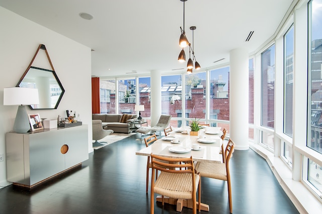 dining room featuring floor to ceiling windows, dark wood finished floors, visible vents, and a city view