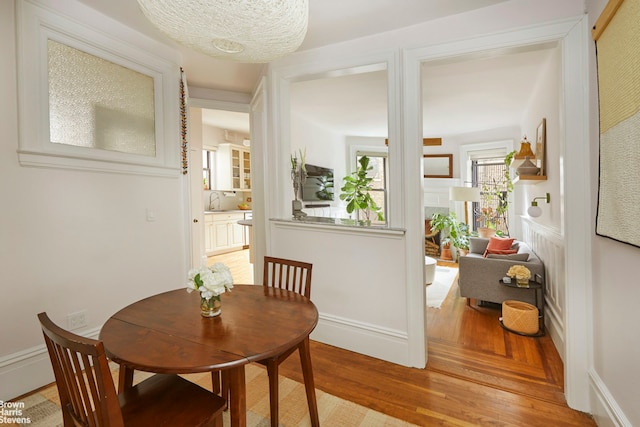 dining space featuring light wood-type flooring and baseboards