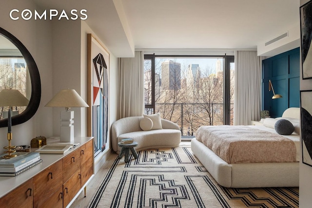 bedroom with multiple windows, visible vents, and wood finished floors