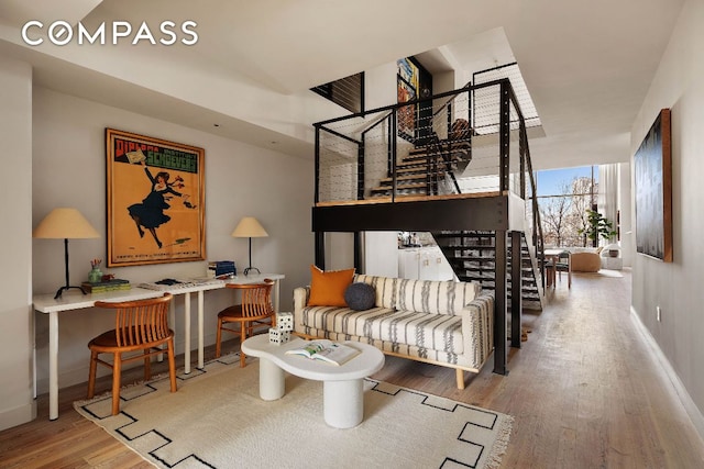 living room with stairway, baseboards, and wood finished floors