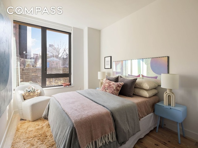 bedroom with baseboards and wood finished floors