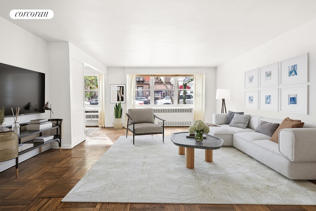 living room with baseboards, plenty of natural light, visible vents, and radiator