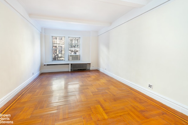 empty room with radiator heating unit, baseboards, and beam ceiling