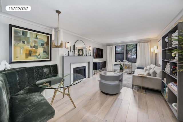 living area with ornamental molding, visible vents, a fireplace, and wood finished floors