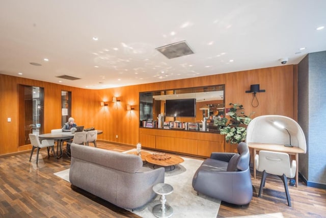 living area featuring recessed lighting, wood walls, and wood finished floors