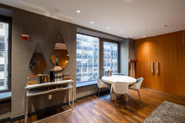 dining room with plenty of natural light, a wall of windows, dark wood finished floors, and recessed lighting