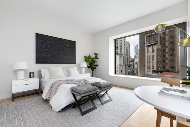 bedroom featuring wood finished floors and a city view