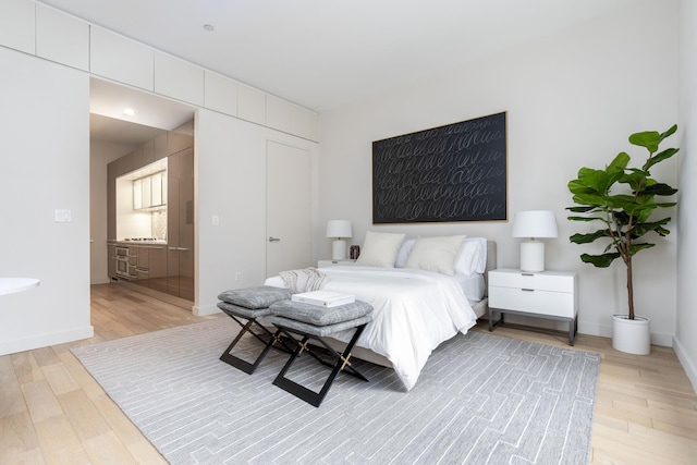 bedroom featuring light wood-style floors and baseboards