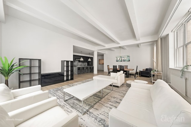 living room with a fireplace, wood finished floors, and beam ceiling