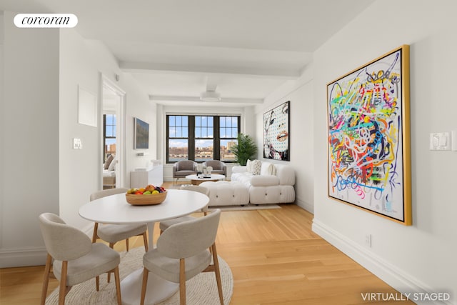 dining room featuring baseboards, beam ceiling, visible vents, and wood finished floors