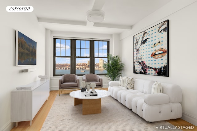 living area with light wood-style floors, visible vents, beamed ceiling, and baseboards