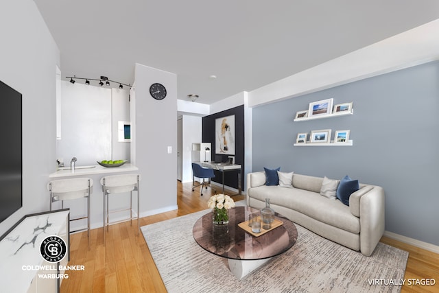 living area with baseboards and wood finished floors