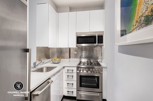 7 E 14th St Unit 1625, New York City, NY 10003 - kitchen with stainless steel appliances, a sink, white cabinetry, light countertops, and tasteful backsplash