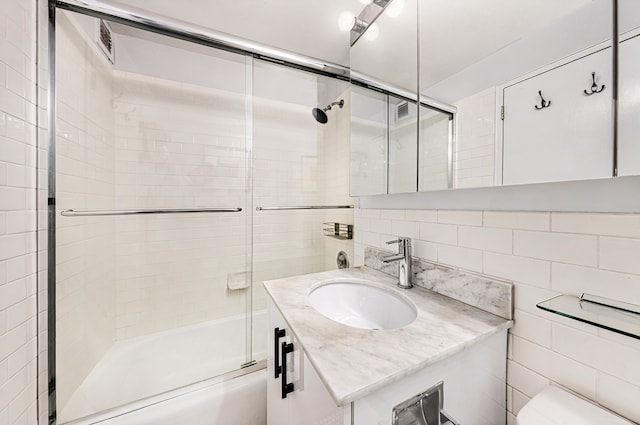 7 E 14th St Unit 1625, New York City, NY 10003 - bathroom with tile walls, vanity, bath / shower combo with glass door, and backsplash