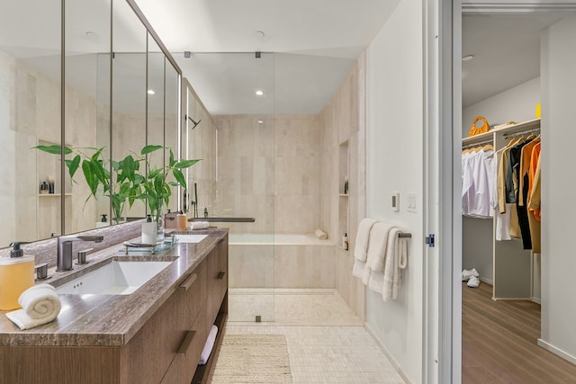543 W 122nd St Unit 18A, New York City, NY 10027 - full bath with double vanity, a shower stall, a spacious closet, baseboards, and wood finished floors