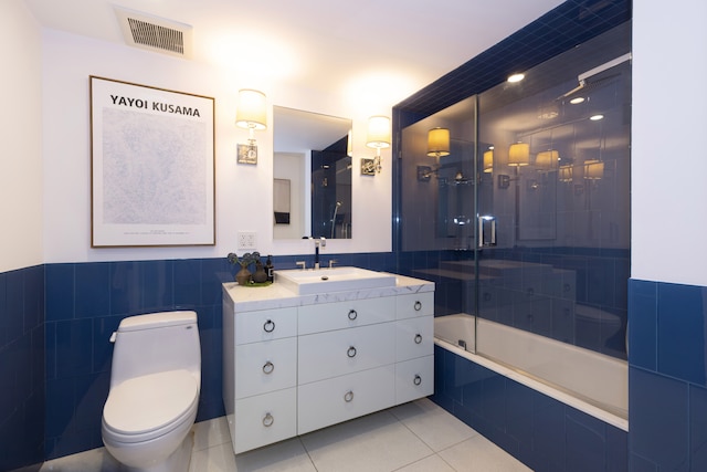 bathroom featuring visible vents, toilet, tile patterned floors, tile walls, and tiled shower / bath