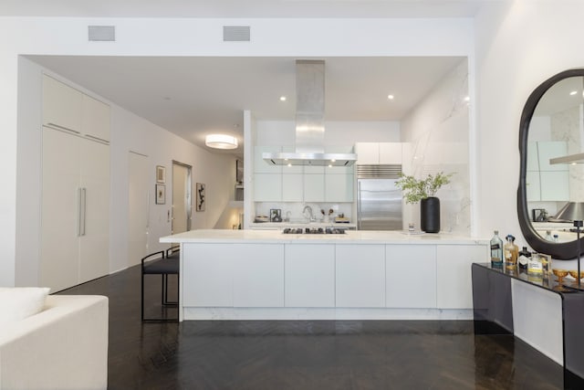 interior space featuring visible vents, modern cabinets, island range hood, and built in fridge