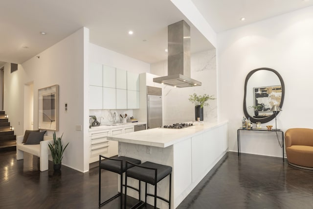 kitchen featuring modern cabinets, island exhaust hood, appliances with stainless steel finishes, a peninsula, and decorative backsplash