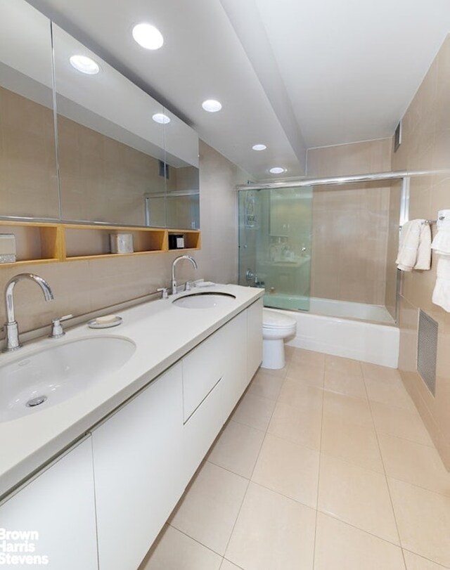 303 E 57th St Unit 32C, New York City, NY 10022 - full bathroom featuring tile patterned floors, combined bath / shower with glass door, a sink, and double vanity
