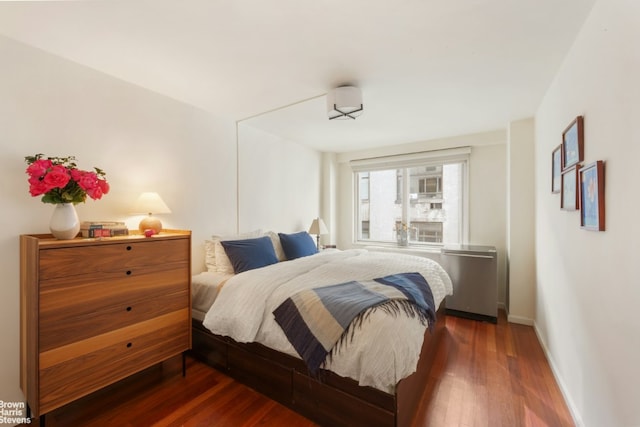 bedroom with dark wood-type flooring and baseboards