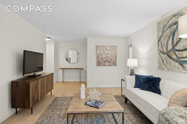 living area featuring baseboards and wood finished floors